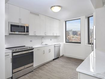 A kitchen with white cabinets and a stainless steel oven.